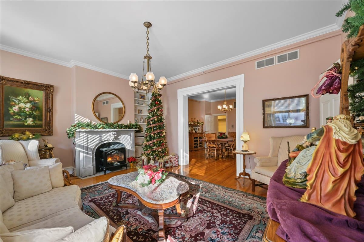A cozy living room featuring a fireplace, festive decorations, and elegant furnishings.